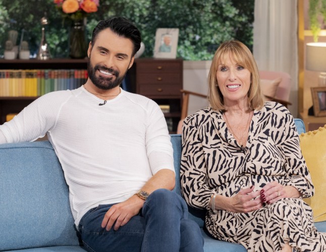 Rylan and Linda Clark sitting on a blue sofa and smiling while appearing on This Morning