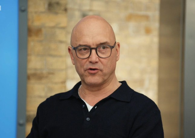 Gregg Wallace wears a black collared shirt and black glasses in a scene from MasterChef.
