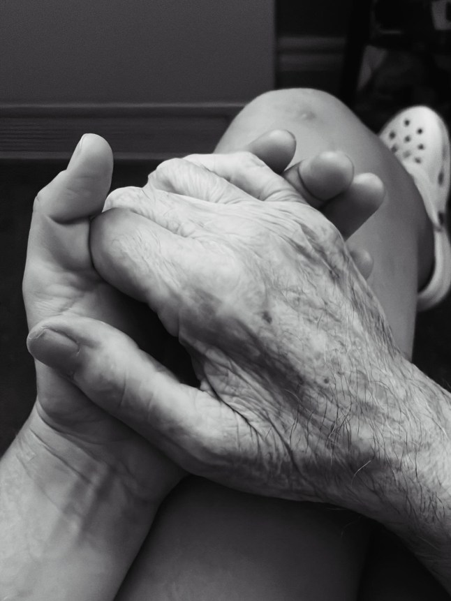 A black and white photo of held hands