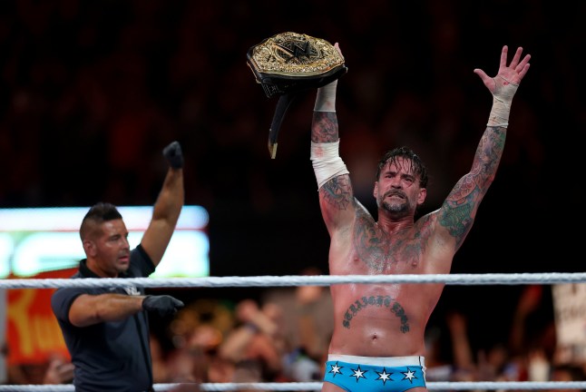 EAST RUTHERFORD, NEW JERSEY - AUGUST 02: CM Punk briefly celebrates after defeated Gunther for the WWE World Heavyweight Championship during the WWE 2025 SummerSlam at MetLife Stadium on August 02, 2025 in East Rutherford, New Jersey. (Photo by Elsa/Getty Images)